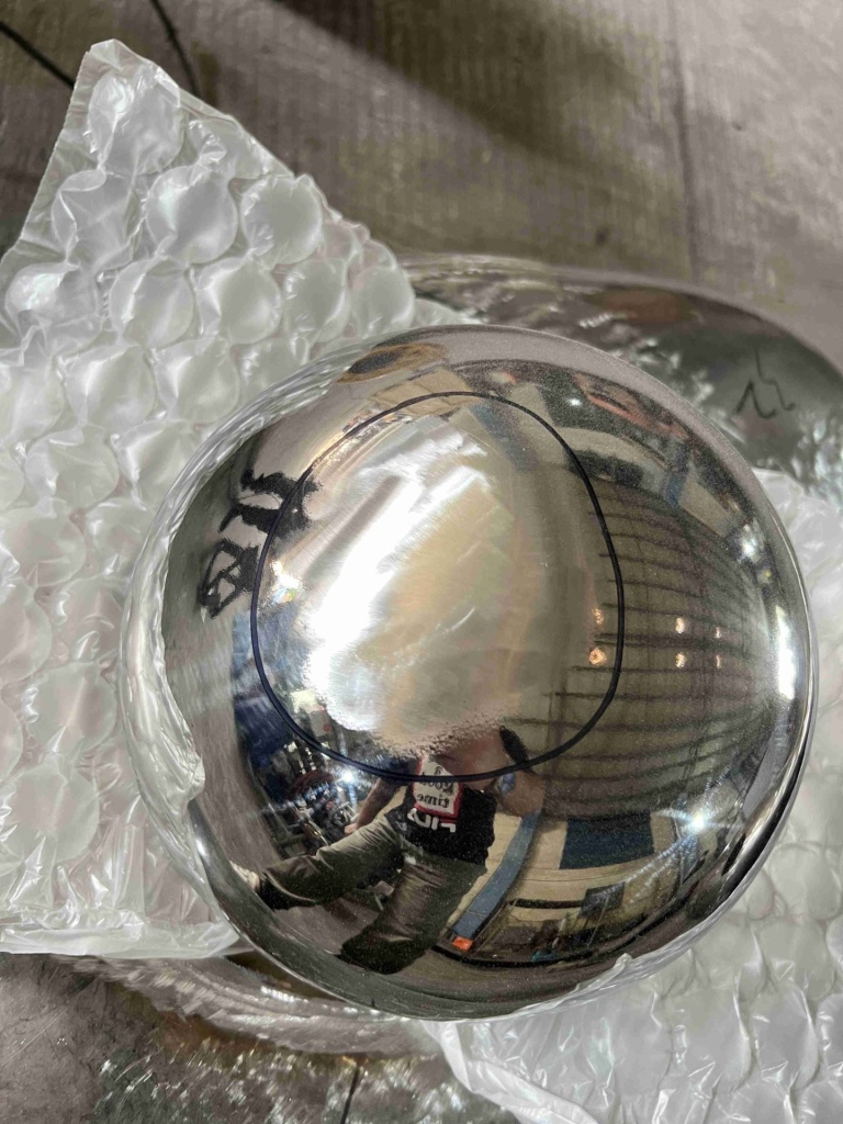 Mirror stainless steel sphere after P600 sanding, with an even matt repair area