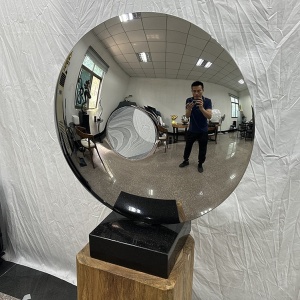 Three-quarter view of the same mirror stainless steel disc sculpture