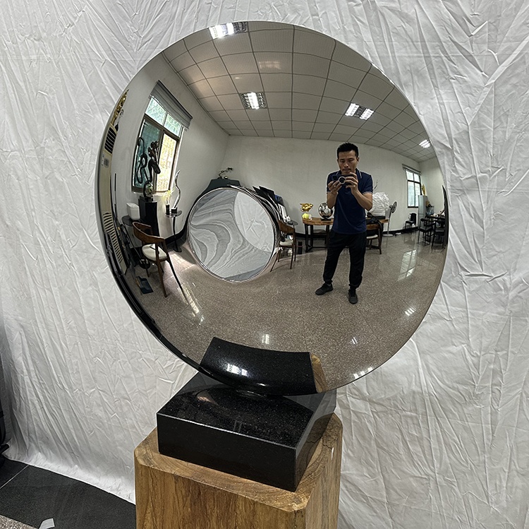 Three-quarter view of the same mirror stainless steel disc sculpture