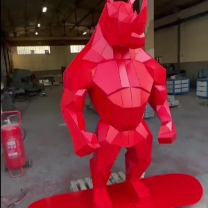 Front view of the same red stainless steel rhino-form sculpture
