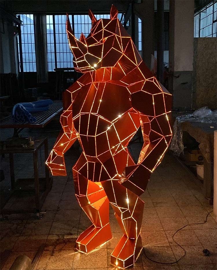 Red geometric stainless steel rhino-form sculpture with integrated LED line lighting