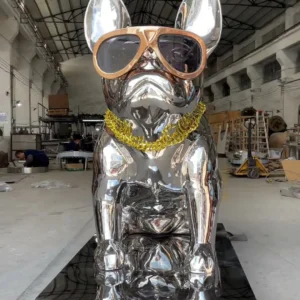 Front view of the same reflective dog sculpture with glasses and a yellow chain on a rectangular mirrored base