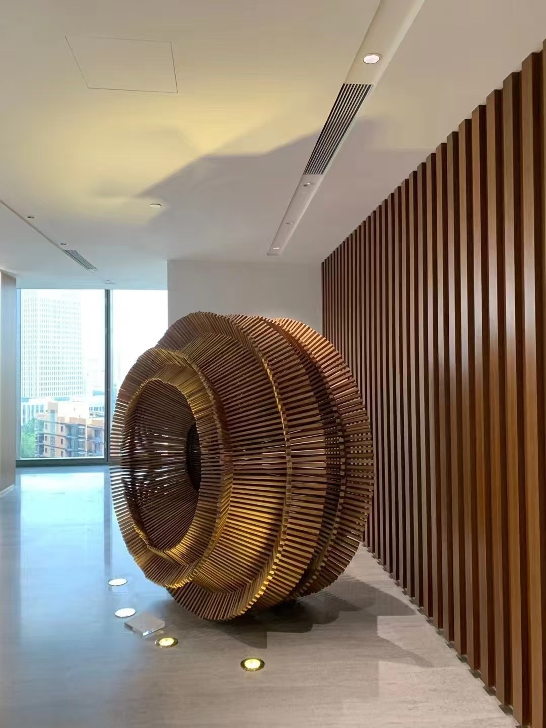 Bronze-tone layered stainless steel ring sculpture in an interior project setting