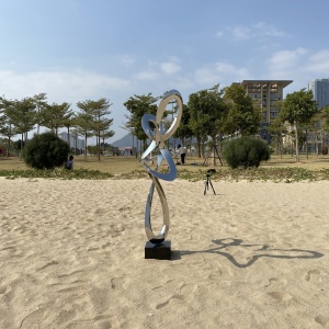 Rear angle of the same mirror stainless steel abstract figure sculpture