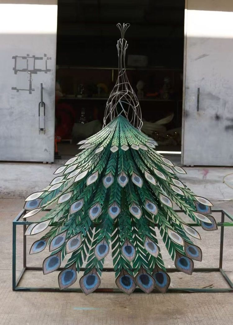Back view of the same painted metal peacock sculpture showing the tail structure and painted finish