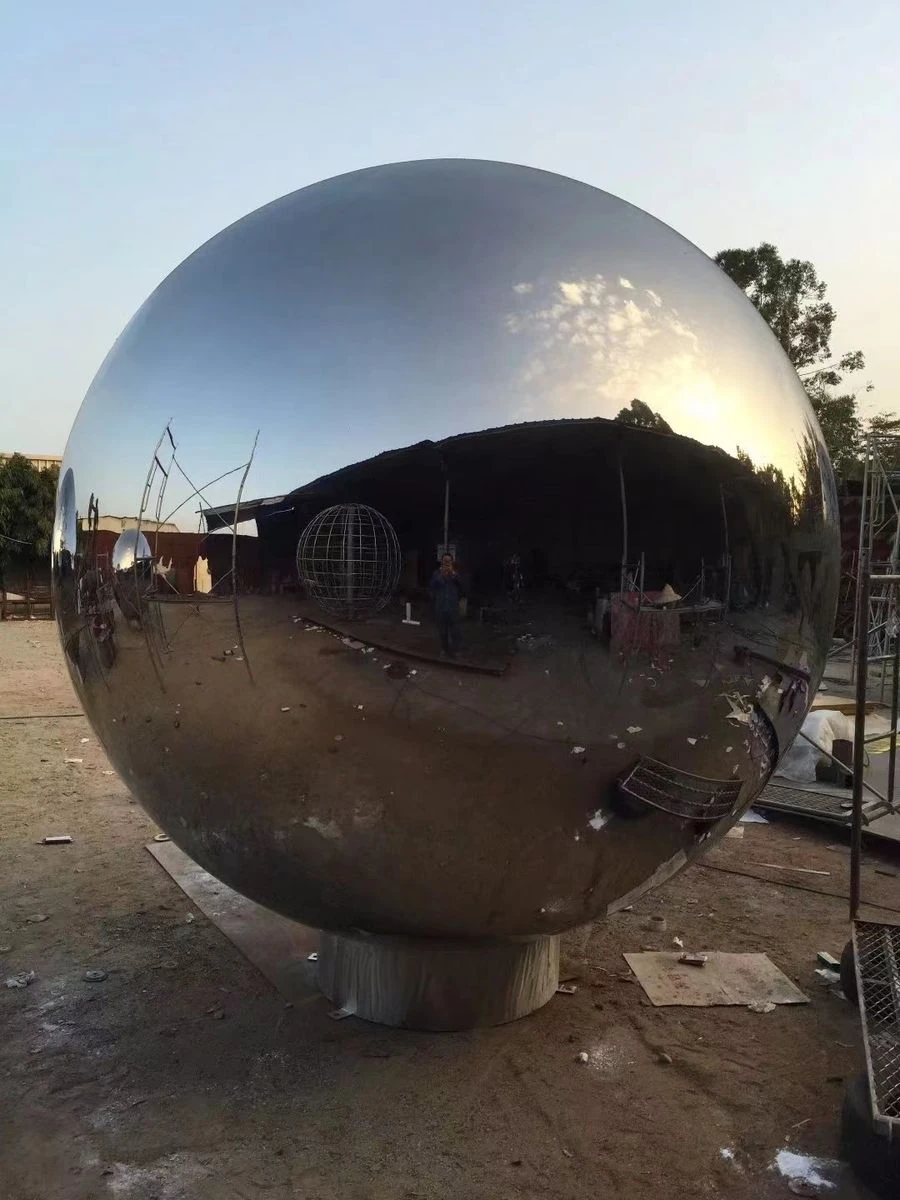 Large mirror-polished stainless steel sphere sculpture reflecting the sky and surroundings without distortion